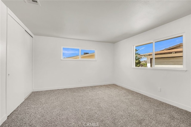 spare room featuring visible vents, baseboards, and carpet floors