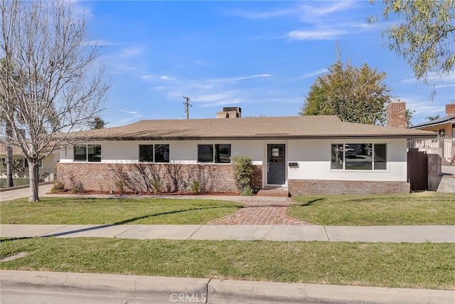 ranch-style house featuring stucco siding, a chimney, and a front yard