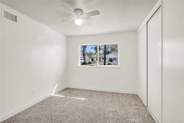 unfurnished bedroom with visible vents, baseboards, light carpet, a closet, and a ceiling fan