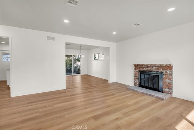 unfurnished living room featuring light wood-style flooring, a fireplace, and visible vents