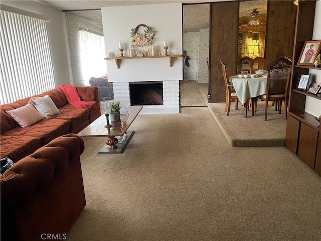 carpeted living area featuring a wealth of natural light, a brick fireplace, and a ceiling fan