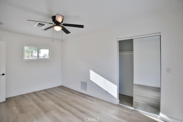 unfurnished bedroom featuring visible vents, a closet, and wood finished floors