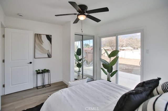 bedroom with ceiling fan, baseboards, wood finished floors, and access to exterior