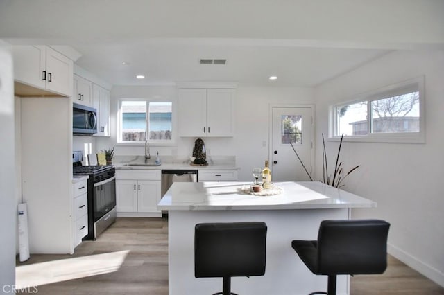 kitchen featuring visible vents, white cabinets, appliances with stainless steel finishes, and a sink