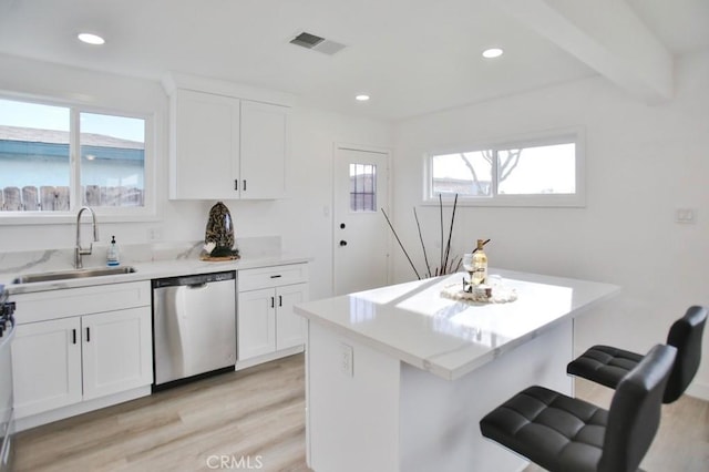 kitchen featuring visible vents, a breakfast bar, a sink, recessed lighting, and dishwasher