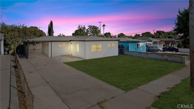 single story home with stucco siding, driveway, a front yard, and fence