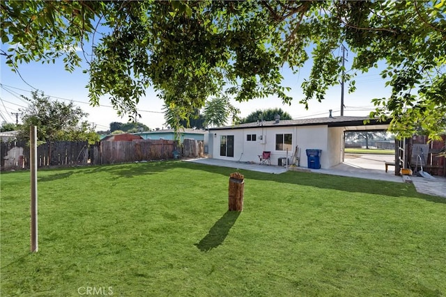 rear view of property with stucco siding, a yard, a fenced backyard, and a patio area