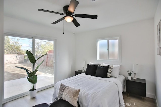 bedroom with baseboards, light wood-style floors, a ceiling fan, and access to outside