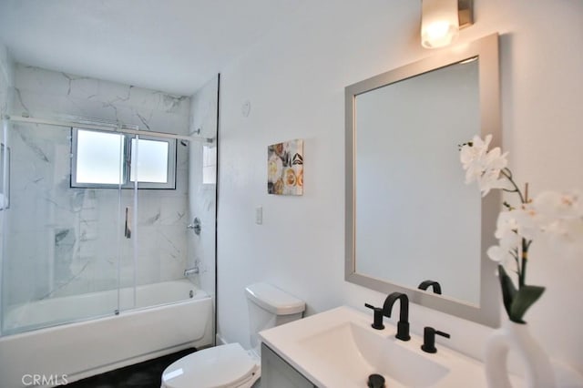 full bathroom featuring combined bath / shower with glass door, toilet, and vanity