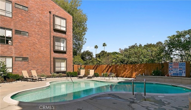 pool featuring a patio area and fence