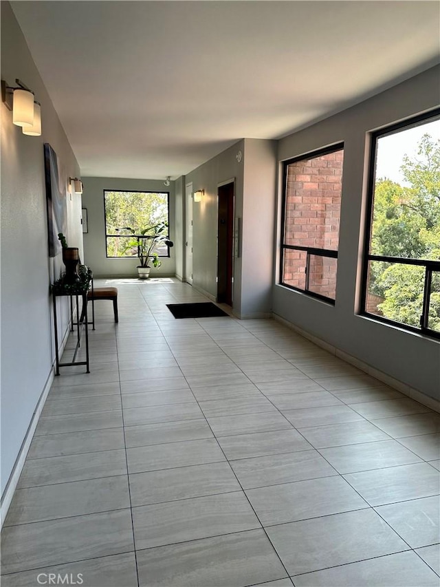 hall with light tile patterned floors and baseboards