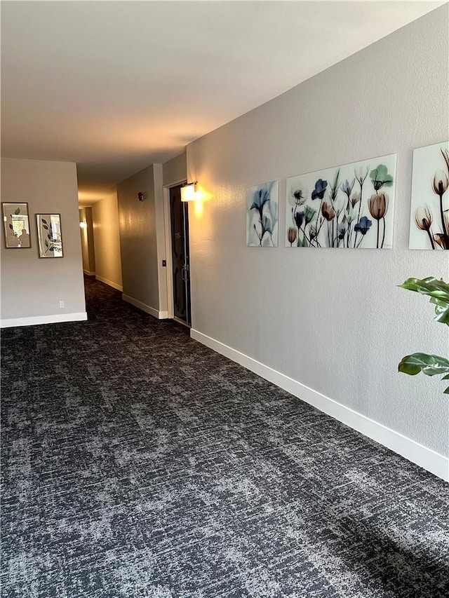 carpeted spare room featuring baseboards