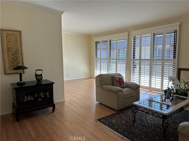 living area featuring wood finished floors, baseboards, and ornamental molding