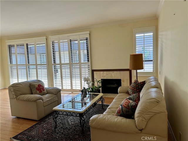 living room featuring a high end fireplace, plenty of natural light, wood finished floors, and crown molding