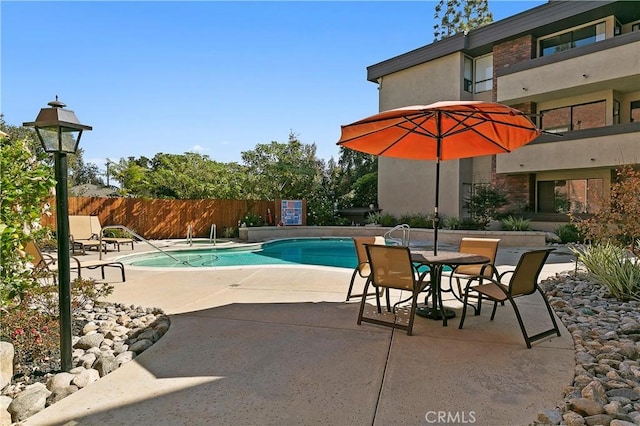 view of swimming pool featuring a patio area, a fenced in pool, and fence