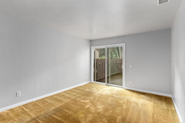 carpeted spare room featuring visible vents and baseboards