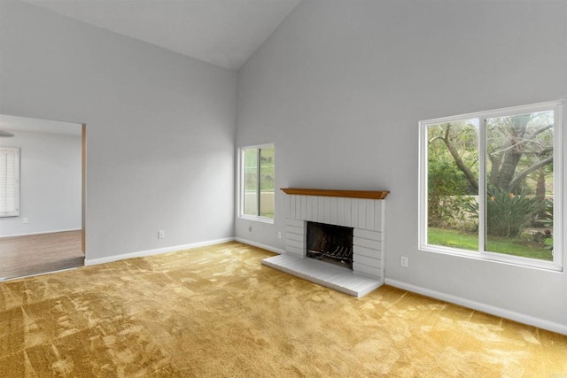 unfurnished living room featuring carpet flooring, a fireplace, high vaulted ceiling, and baseboards