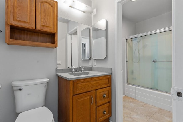 full bathroom with combined bath / shower with glass door, toilet, vanity, and tile patterned flooring