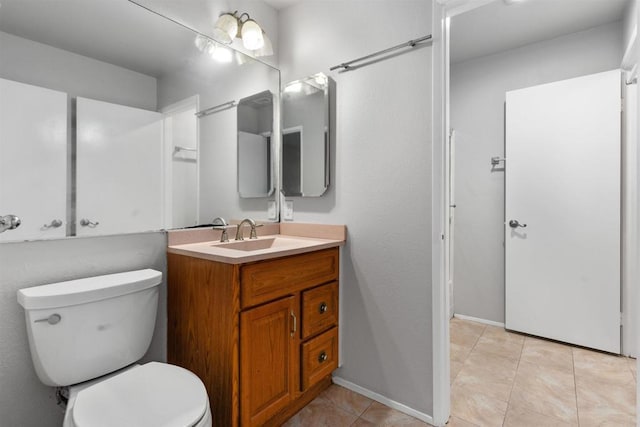 bathroom featuring vanity, toilet, baseboards, and tile patterned flooring