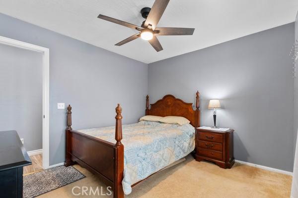 carpeted bedroom featuring baseboards and ceiling fan