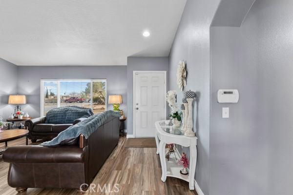 living area with baseboards and wood finished floors