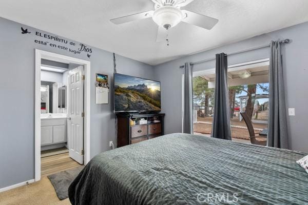 carpeted bedroom featuring access to exterior, ceiling fan, ensuite bathroom, and baseboards