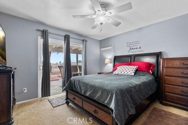 carpeted bedroom featuring baseboards, access to exterior, and a ceiling fan