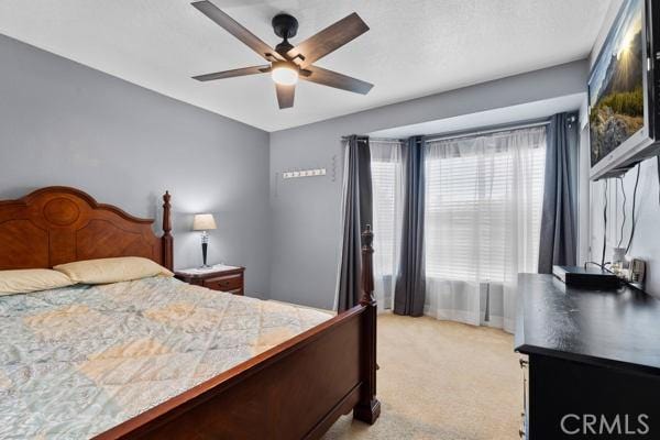 bedroom with light colored carpet and a ceiling fan