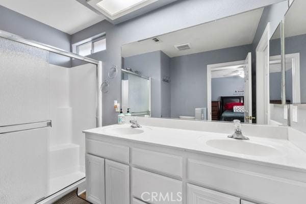 ensuite bathroom with visible vents, a stall shower, a sink, ensuite bath, and double vanity