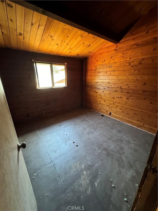 empty room featuring wood ceiling, wood walls, and vaulted ceiling with beams