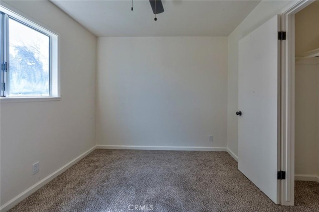 carpeted empty room with baseboards and ceiling fan