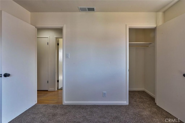 unfurnished bedroom with visible vents, baseboards, a closet, and carpet flooring