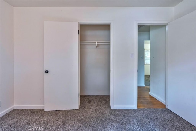 unfurnished bedroom featuring a closet, carpet floors, and baseboards