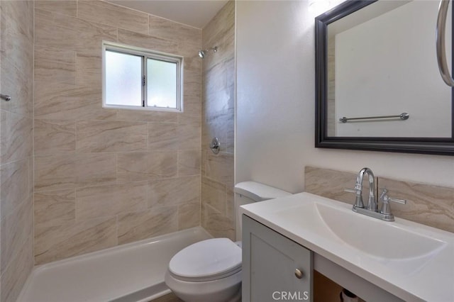 bathroom with vanity, toilet, and tiled shower