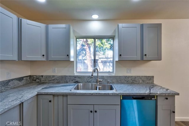 kitchen featuring a sink, dishwashing machine, and baseboards