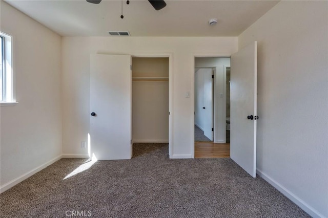 unfurnished bedroom featuring carpet, visible vents, baseboards, ceiling fan, and a closet