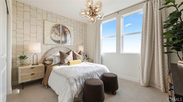 carpeted bedroom featuring wallpapered walls, an inviting chandelier, baseboards, and an accent wall