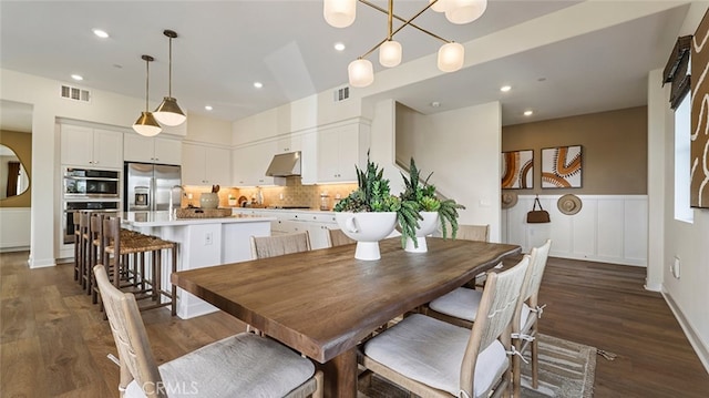 dining area with recessed lighting, visible vents, dark wood-type flooring, and wainscoting