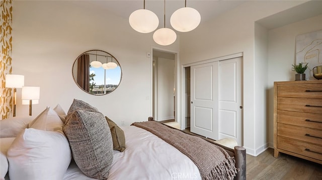 bedroom featuring a closet, baseboards, and wood finished floors