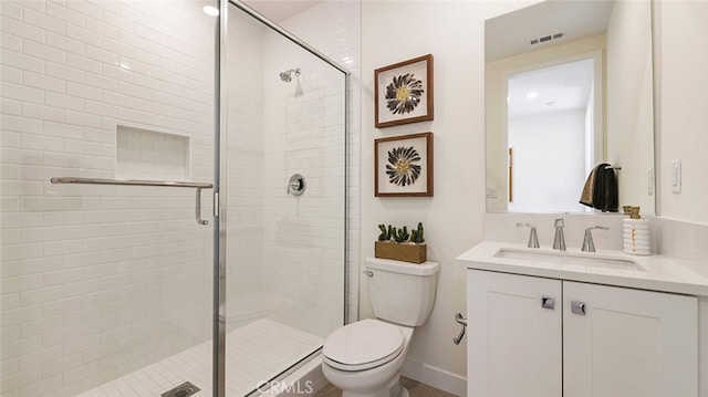 bathroom with vanity, toilet, visible vents, and a stall shower