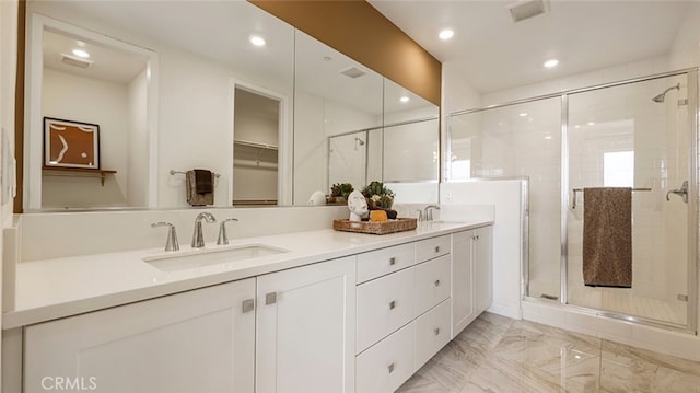 bathroom featuring visible vents, marble finish floor, a stall shower, a sink, and double vanity