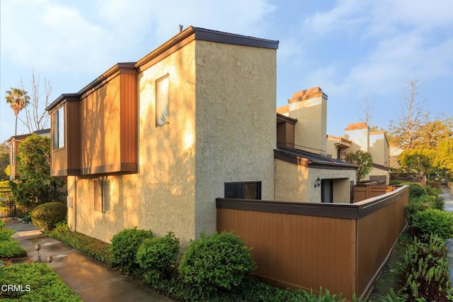 view of home's exterior featuring stucco siding and fence