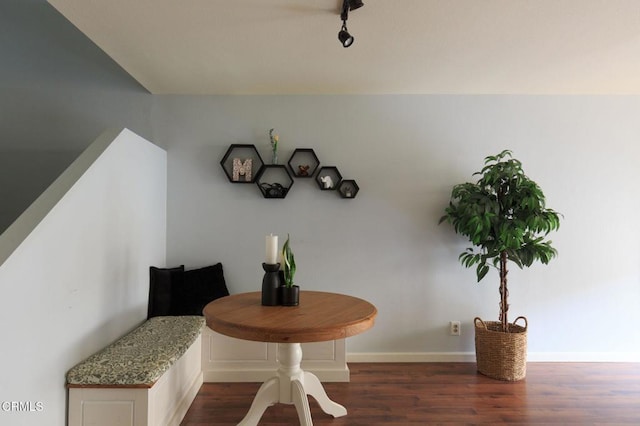 dining area with baseboards and dark wood-type flooring