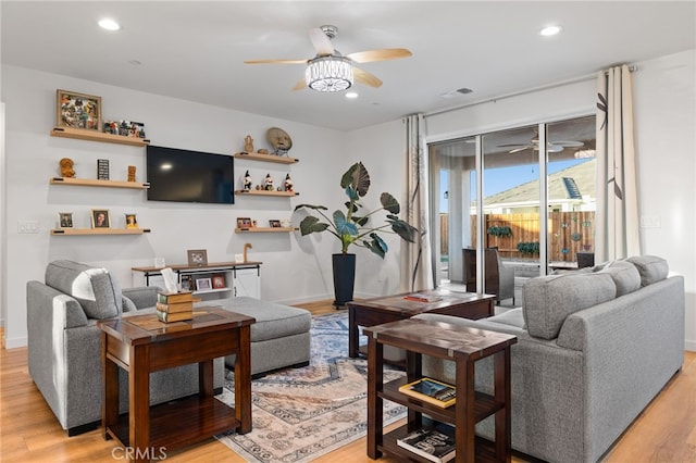 living room featuring recessed lighting, a ceiling fan, baseboards, and light wood finished floors