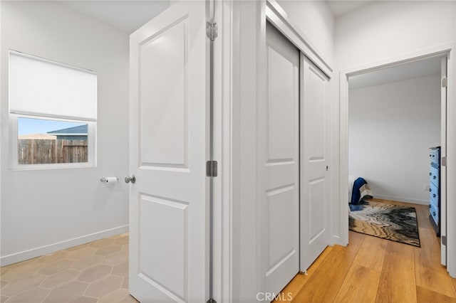 hallway with light wood finished floors and baseboards