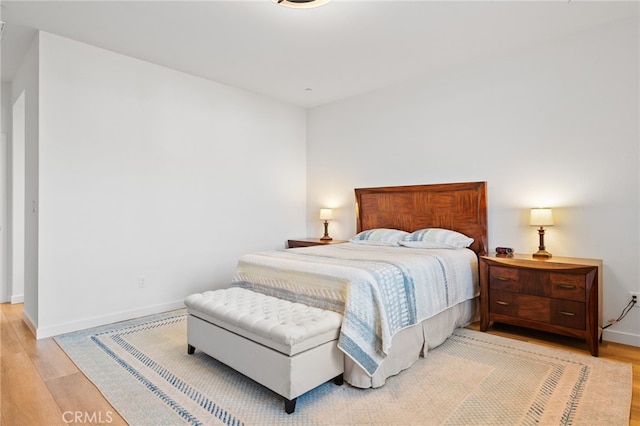 bedroom featuring baseboards and light wood finished floors