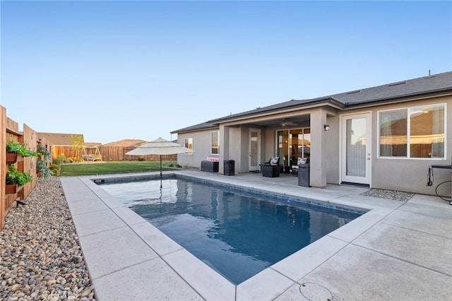 view of swimming pool featuring a patio area, a fenced in pool, a ceiling fan, and a fenced backyard