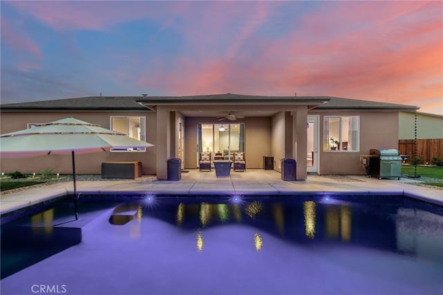 pool at dusk featuring a fenced in pool, ceiling fan, fence, a patio area, and a grill