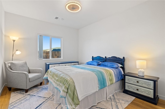 bedroom featuring wood finished floors, visible vents, and baseboards