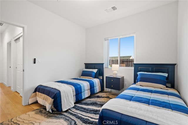 bedroom with visible vents and wood finished floors